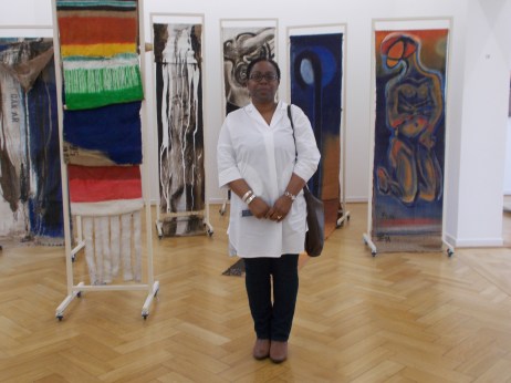 Carol Dixon in front of paravents produced by El Hadji Sy in 2013. These works were designed as double-sided mobile sculptures attached to aluminium frames produced by Mathis Esterhazy.