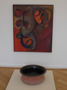 Untitled (1992) oil on canvas by El Hadji Sy, displayed with a Brazilian pot from the Weltkulturen Museum collection.