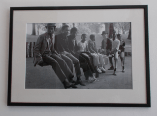 A framed image of "Young Men on a Seesaw" (1984), by Vanley Burke.