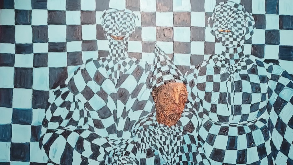 Artwork comprising three figures, designed to camouflage against a blue and black, checker-board effect background. Acrylic on canvas, c.250x300cm.