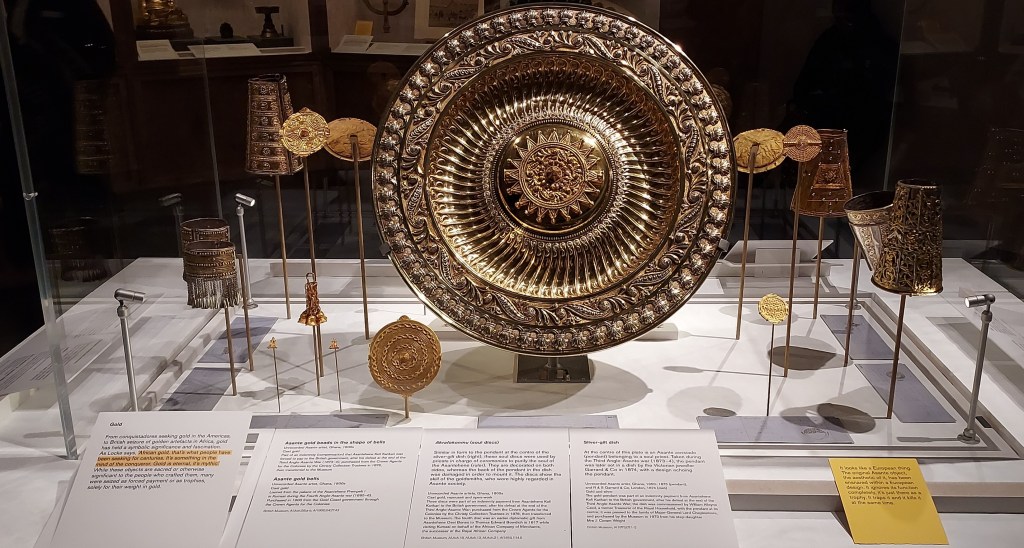 A collection of Asante gold bells, pendants, armlets and a large decorative plate.