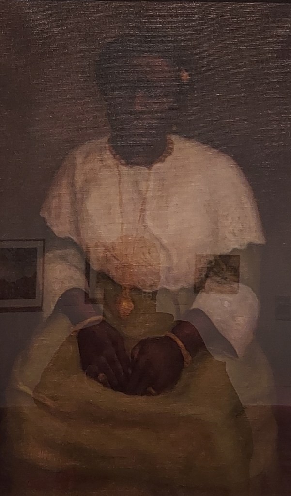 Portrait of a wealthy Nigerian woman, painted in 1922, dressed in fine lace clothing and gold jewellery.