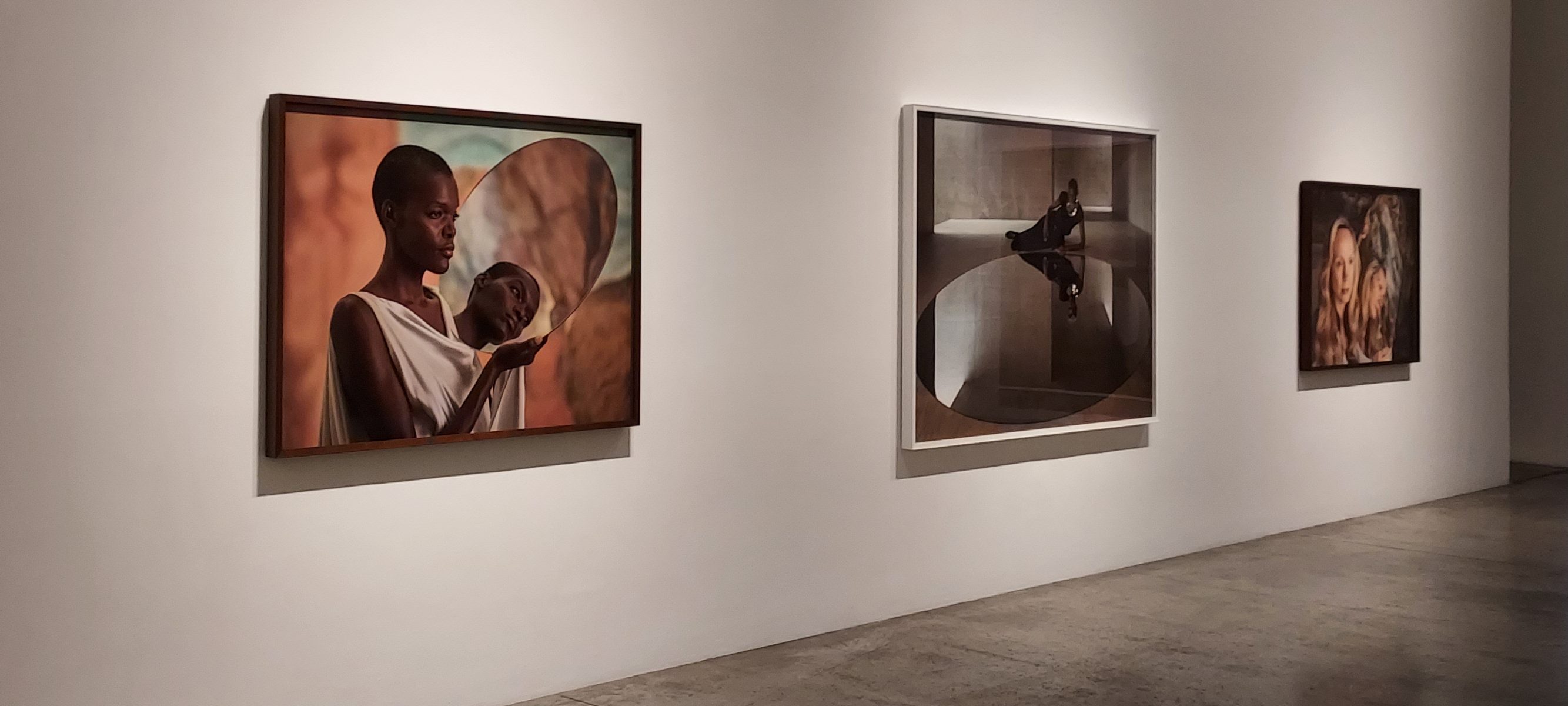 Three framed photographic prints displayed on the wall inside an art gallery.